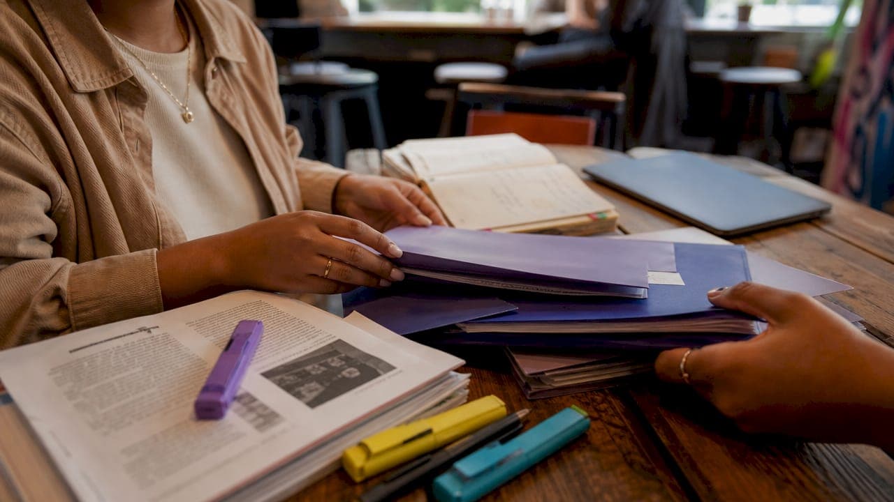 Hands organizing citation folders on desk